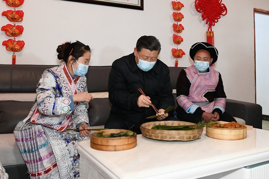2021年2月3日下午，習近平在貴州畢節(jié)市黔西縣新仁苗族鄉(xiāng)化屋村苗族村民趙玉學家，同一家人邊聊家常邊制作當?shù)貍鹘y(tǒng)節(jié)日食品黃粑。新華社記者 李學仁 攝